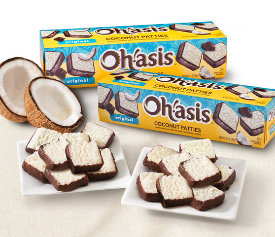 Chocolate Covered Coconut Patties in boxes with coconut halves and treats on plates.