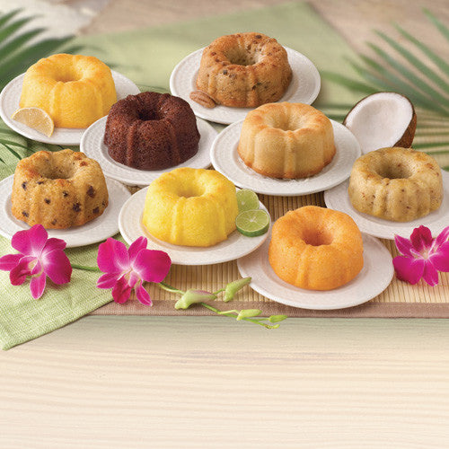 Dockside Mini Bundt Cake Sampler featuring tropical flavors on white plates with flowers and greenery.